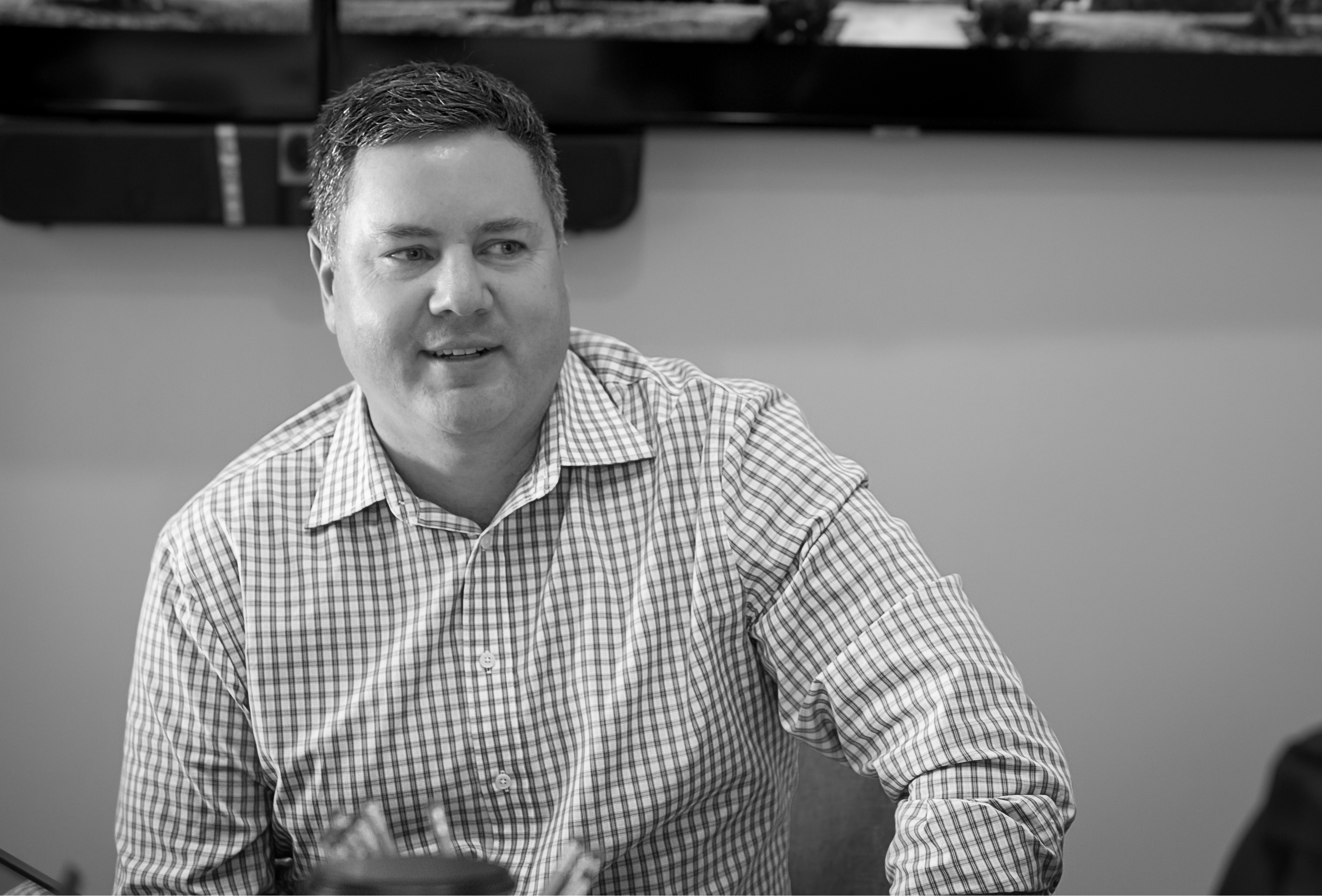 Patrick Van Pelt in a business meeting, black and white portrait.